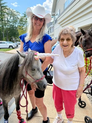 Resident and staff member with a miniature unicorn horse