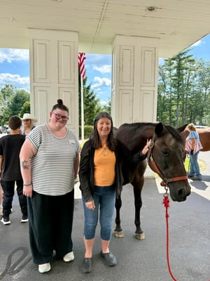Residents interacting with a horse outside the facility