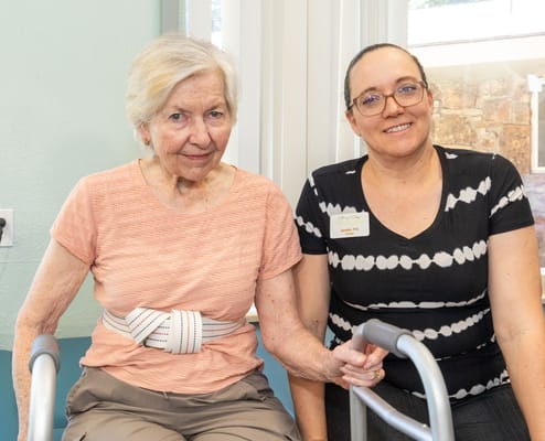 Resident and staff member smiling together in an activity area