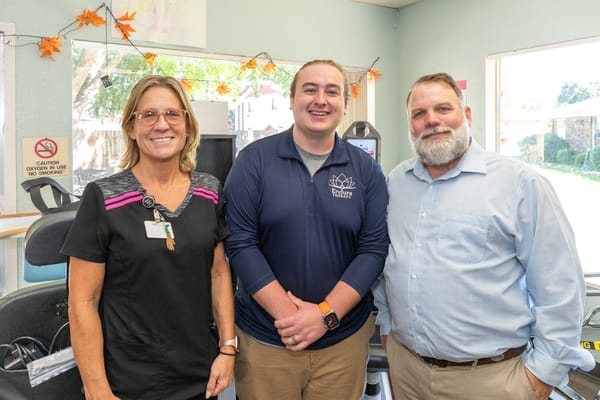 Staff and administrator posing in an activity area