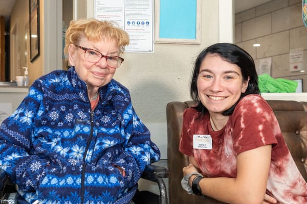 Resident and staff member smiling in a common area