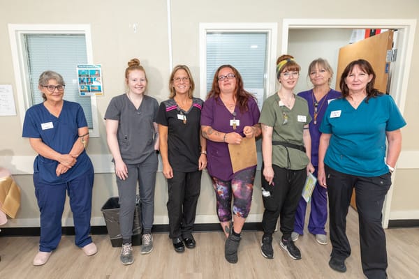 Staff members posing in a facility hallway