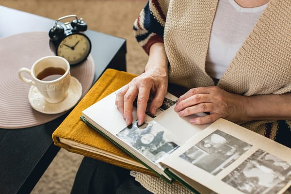 A resident looking through an album with a cup of tea