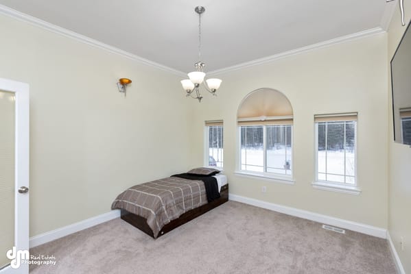 A cozy private room with a single bed and large windows