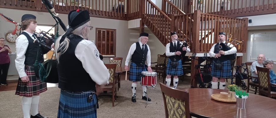 Residents enjoying a live performance by a bagpipe band