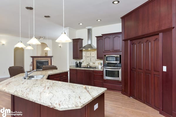 Modern kitchen with dark wood cabinetry and granite countertops