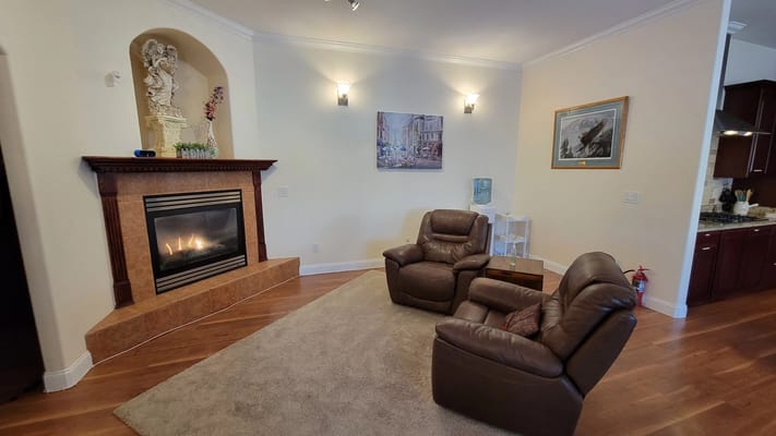 Cozy lounge area with two recliner chairs and a fireplace