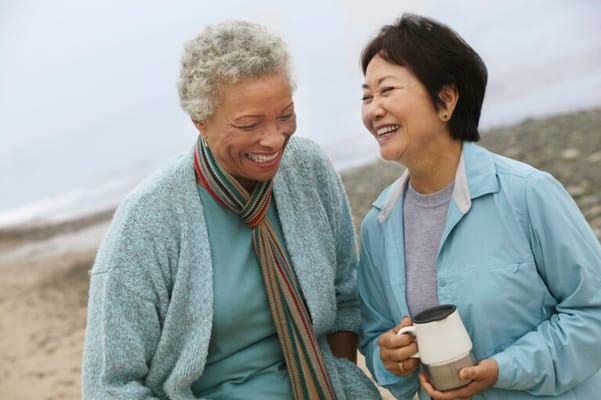 Two women enjoying a moment outdoors by the beach