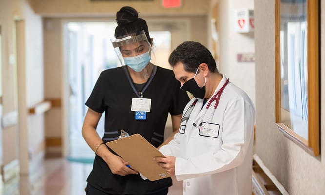 Staff discussing resident care in a hallway