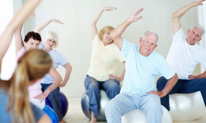 Seniors participating in an exercise class indoors