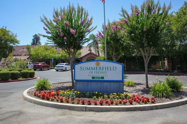 Sign for Summerfield of Fresno memory care facility surrounded by flowers