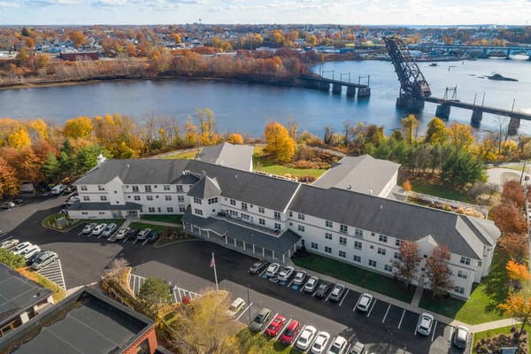Aerial view of a senior living facility by a river
