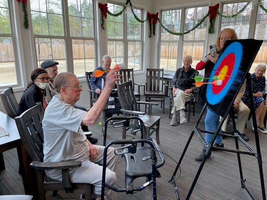Residents participating in a dart activity indoors