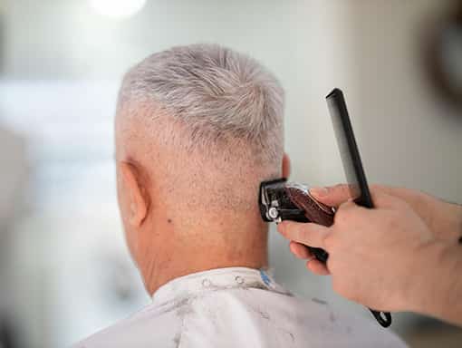 A resident receiving a haircut in a salon setting