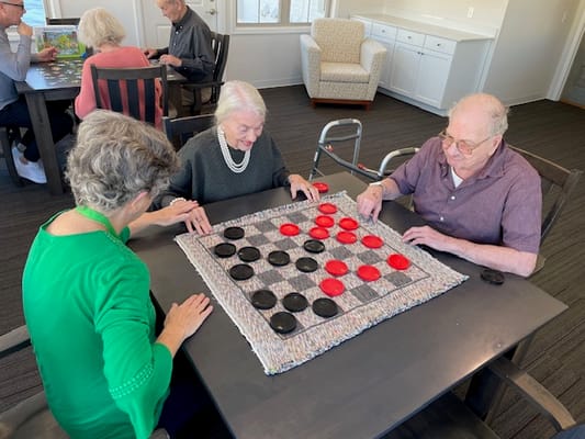 Residents engaged in a game of checkers in a common area