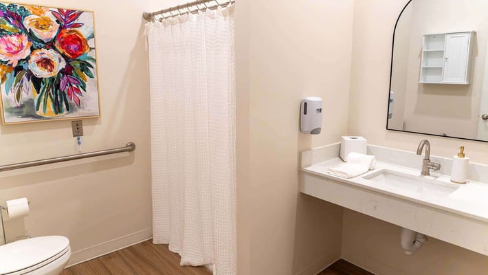 A tidy bathroom with flowers and modern fixtures