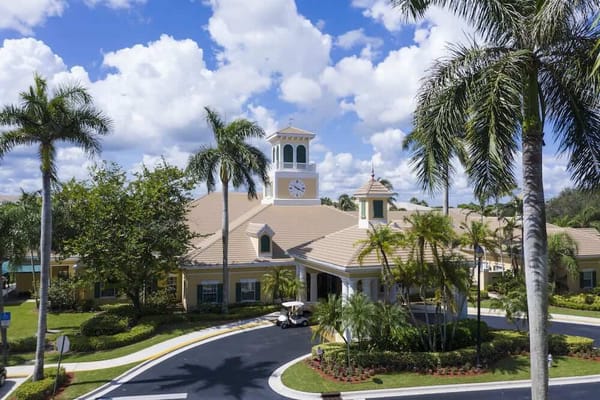 Exterior view of a senior living facility with palm trees