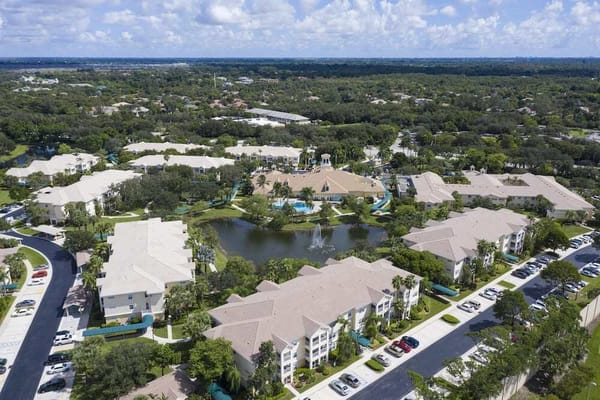 Aerial view of a large senior living campus with gardens and water features
