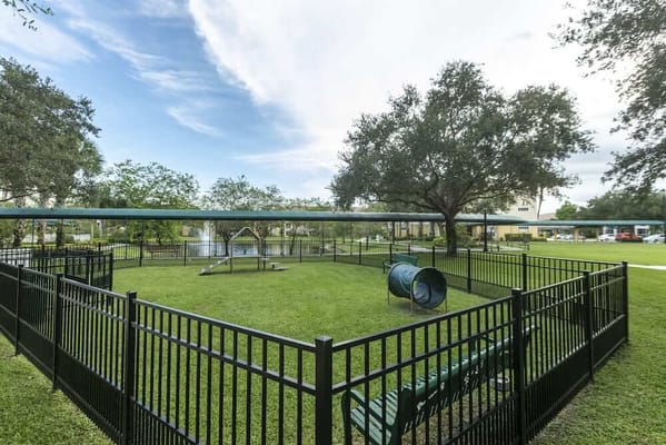 Fenced outdoor space with seating and play equipment