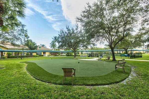 Putting green surrounded by trees and benches