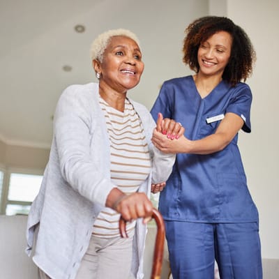 A caregiver assisting a resident in a bright indoor space