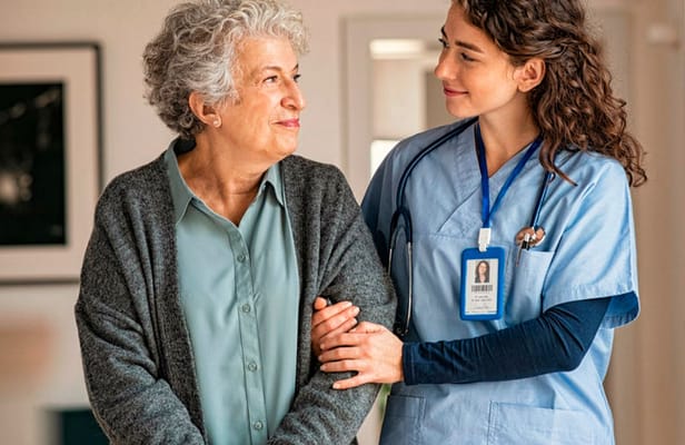 Healthcare staff assisting a senior resident indoors