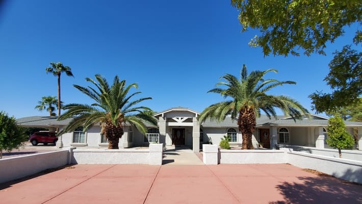 Exterior view of Five Roses Adult Care Home III with palm trees