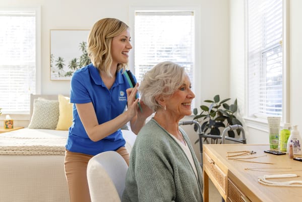 Staff providing hair care to a resident in a cozy room