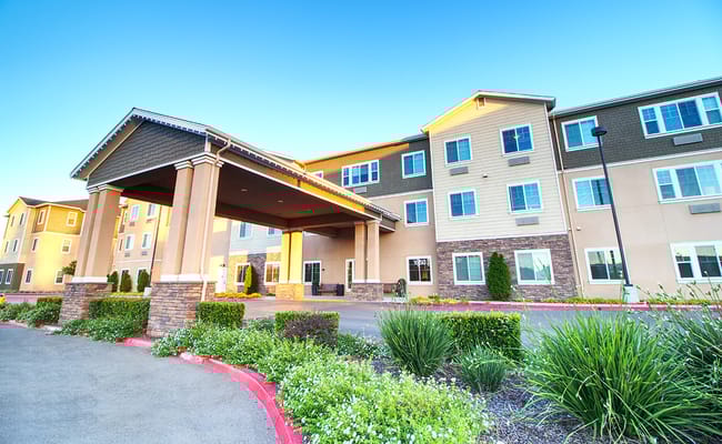 Exterior view of a senior living facility with a covered entrance