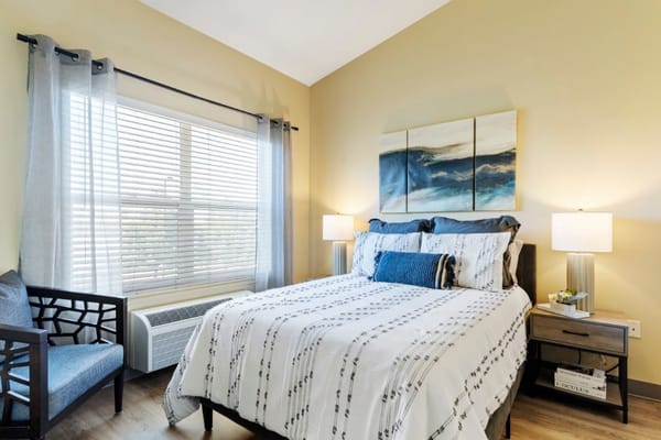 Brightly decorated resident room with bed and chair