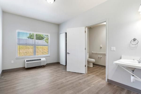 A private resident room with a bathroom and window