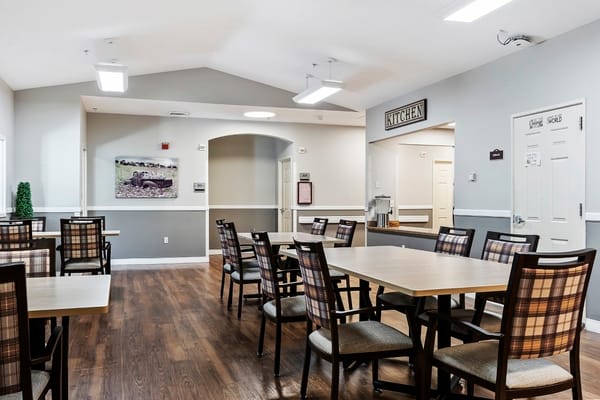 Dining area with tables and chairs in an assisted living facility