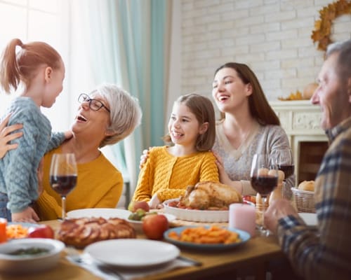 Family gathering at a table with food and drinks