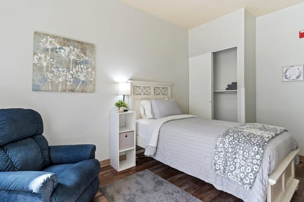 Cozy resident bedroom with a chair and lamp