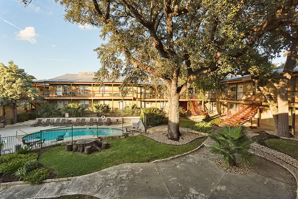 Outdoor pool area surrounded by lush greenery