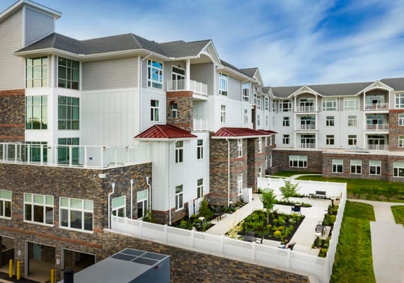 Exterior view of a senior living facility with gardens