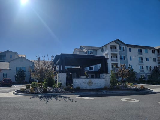 Entrance area with a pavilion and landscaping at Revel Rancharrah senior living facility