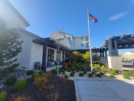 Exterior entrance of Revel Rancharrah senior living facility with landscaped gardens.