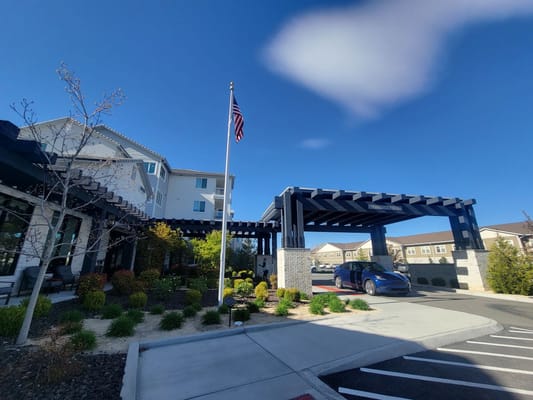 Main entrance with flagpole and landscaping at Revel Rancharrah