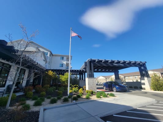 Front entrance of Revel Rancharrah with flag and landscaped area.