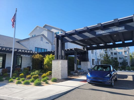 Modern entrance of Revel Rancharrah with landscaping and an American flag.