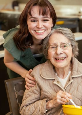 Staff member with a resident smiling together