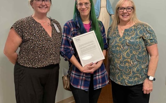 Staff members presenting an award to a resident