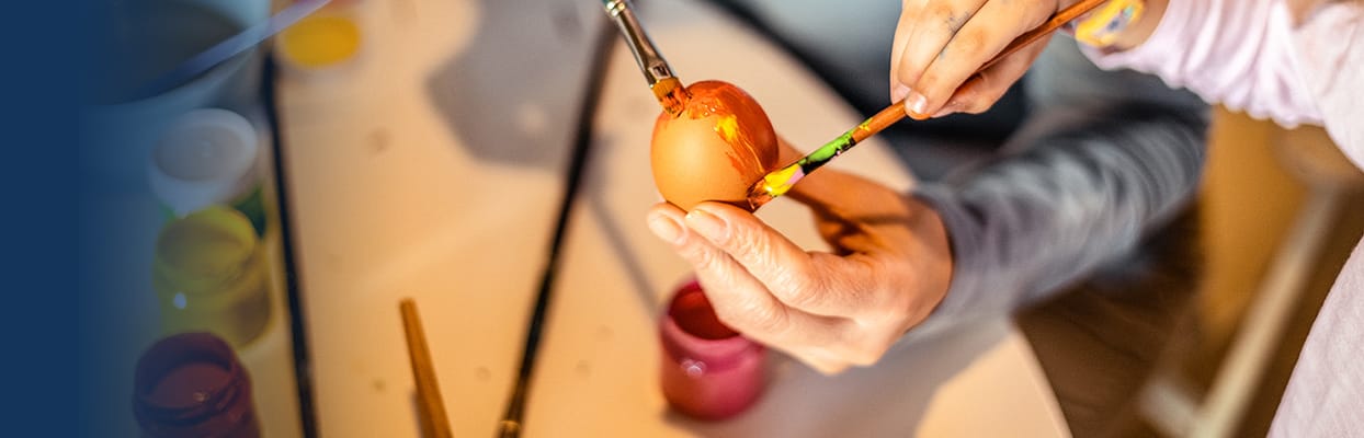 A resident painting an Easter egg during an activity