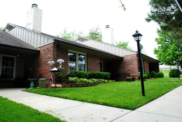 Exterior view of a senior living facility with green lawn