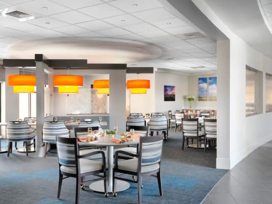 Bright dining room with modern decor and tables set for meals