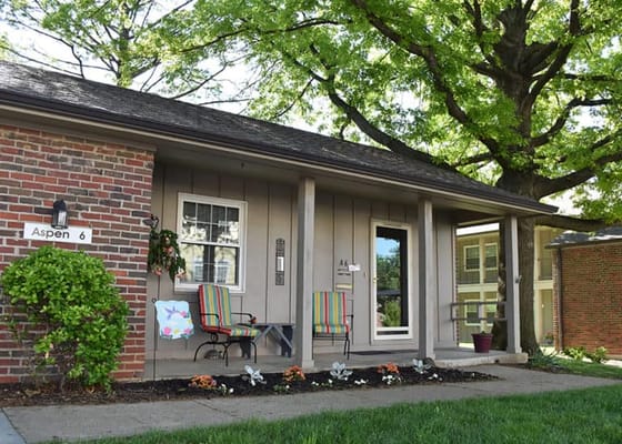 Front entrance of a senior living unit with colorful chairs
