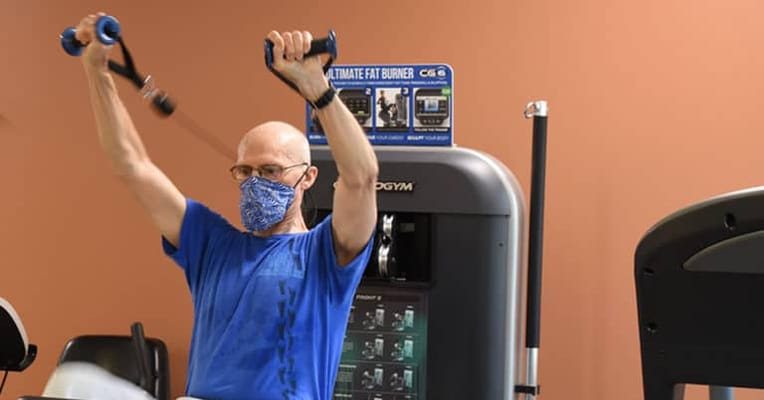Senior exercising in a fitness center with equipment