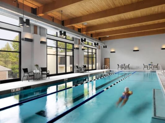 Indoor swimming pool with natural light and seating