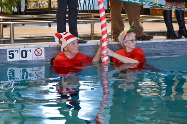 Residents enjoying a fun pool activity in Christmas attire